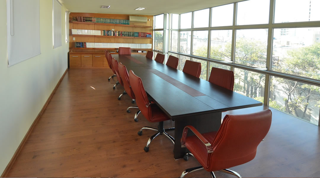 Sala de reuniones amplia de LG & Asociados con ventanal y biblioteca de doctrina